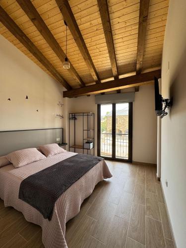 a bedroom with a large bed and a large window at Hotel Rural El Pingón in Manzanal de Arriba