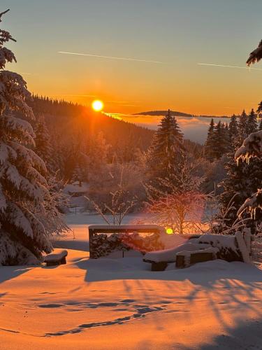 a winter sunset with the sun setting in the distance at Horní Mísečky - F10 apartmán u sjezdovky in Horni Misecky