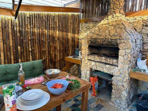 Una sala de estar con una mesa y una chimenea de piedra. en ДАЧА ЛеДАЧА, en Zatoka