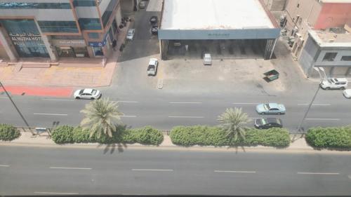 an aerial view of a street with cars and palm trees at فندق شعاع النزهة in Az Zāhir