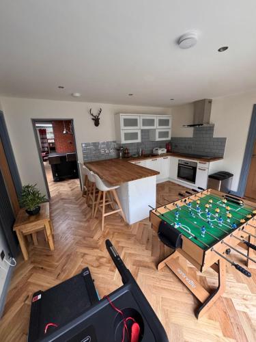 a living room with a table with a chessboard on it at Luxurious Cottage on the River of Portree with Hot Tub! in Portree