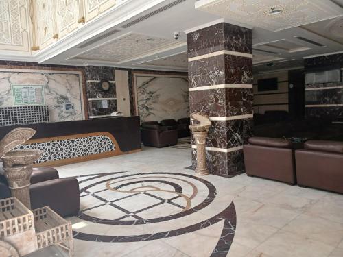a lobby with couches and a rug on the floor at فندق شعاع النزهة in Az Zāhir
