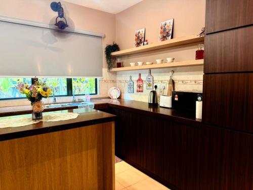 a large kitchen with a counter with flowers on it at Sunway Lakeside Bungalow in Ipoh in Ipoh