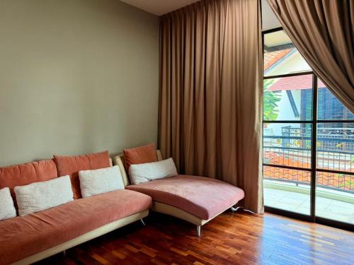 a living room with a couch and a large window at Sunway Lakeside Bungalow in Ipoh in Ipoh