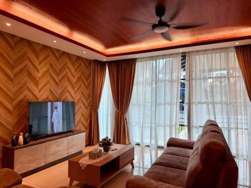 a living room with a couch and a flat screen tv at Sunway Lakeside Bungalow in Ipoh in Ipoh