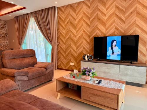 a living room with a couch and a tv at Sunway Lakeside Bungalow in Ipoh in Ipoh