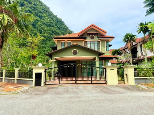 a house with a gate and a mountain at Sunway Lakeside Bungalow in Ipoh in Ipoh