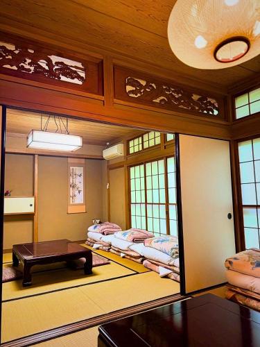 a room with three beds and a table in it at 雲の園 箱根 Kumo Inn Hakone in Hakone