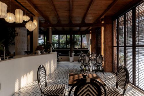 a room with chairs and a table and windows at M ORIGINAL VILLA in Jinghong