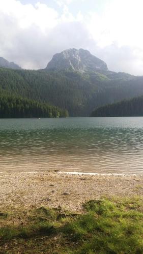 a large body of water with a mountain in the background at Rooms Apartment Durmitor in Žabljak