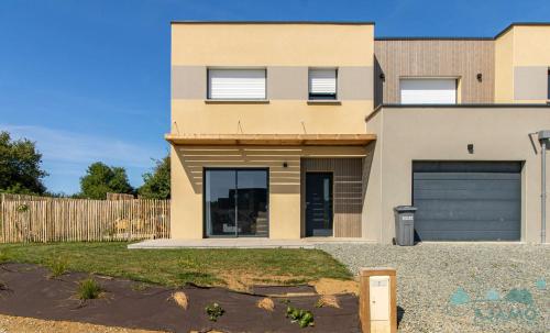 a house with a garage in front of it at 354 - Maison neuve en plein cœur de Plévenon. in Plévenon
