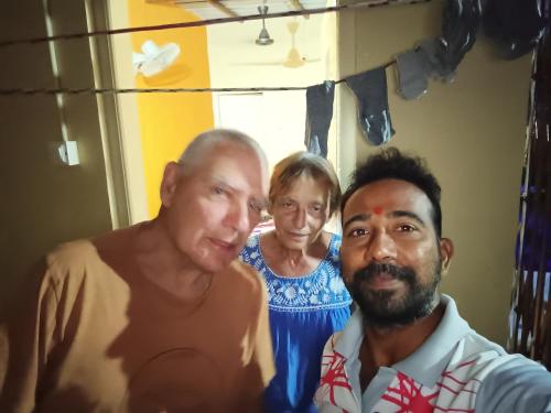 two men and a woman standing in a room at Ashok Home Stay in Hampi