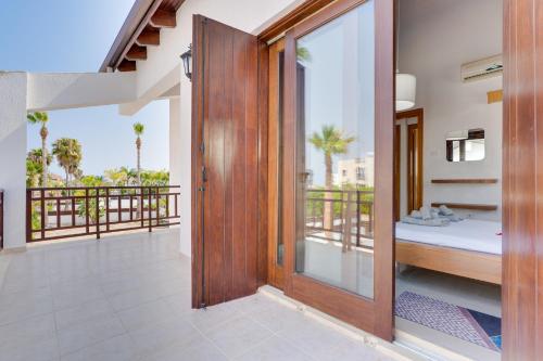 a room with a balcony with a bed and a sliding glass door at Amelia Beach Villa Wpool -500mfrombeach in Pyla