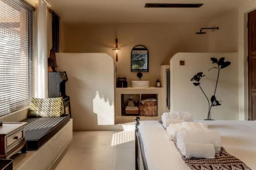 a bedroom with a bed and a couch and a refrigerator at M ORIGINAL VILLA in Jinghong