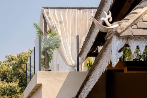 a house with a balcony with a plant on it at M ORIGINAL VILLA in Jinghong