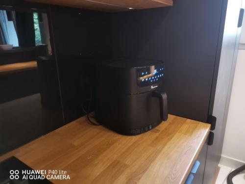 a black appliance sitting on top of a wooden table at Niesamowita nowoczensa kawalerka in Otwock