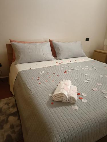 a bed covered in confetti with two towels and pills at Il nido del Poeta in Recanati