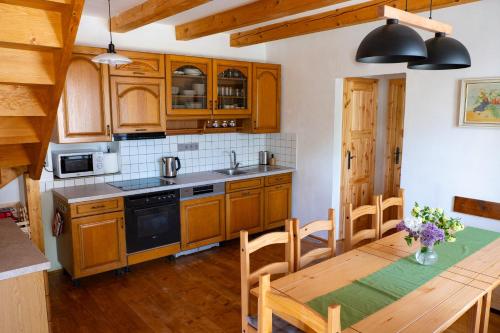 a kitchen with wooden cabinets and a wooden table with a dining room at chalupa Pelechy in Kowářow