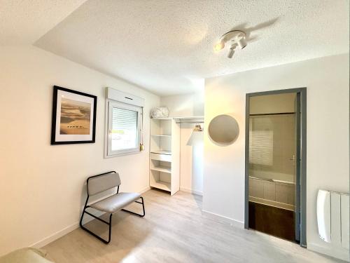 a room with a chair and a walk in closet at Appartement calme parking in Le Monastère
