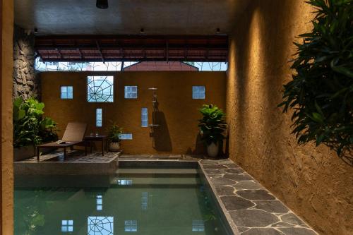 a swimming pool in a building with a room with windows at Wazen Retreat Villa Danang in Da Nang