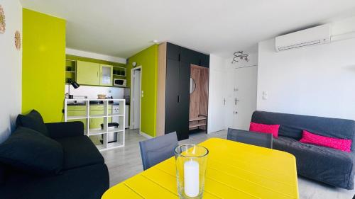 - un salon avec une table jaune et un canapé dans l'établissement Le Temple du Soleil, Mer et Plage, à La Grande Motte