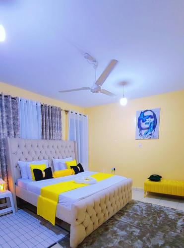 a bedroom with a large bed with yellow and white at Marvel Homes Two Bedroom Air-Bnb Mombasa Bamburi in Bamburi