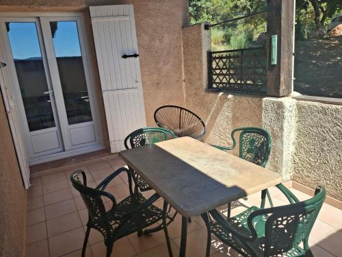 a table and chairs on a patio with a door at appartement confortable in Sainte-Croix-de-Verdon