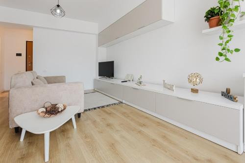 a living room with a couch and a table at City Center Accommodation - 404 in Reşiţa