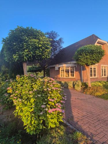 a house with a bunch of flowers in front of it at Luxe vakantiehuis op de Veluwe met tuin in Barneveld in Barneveld