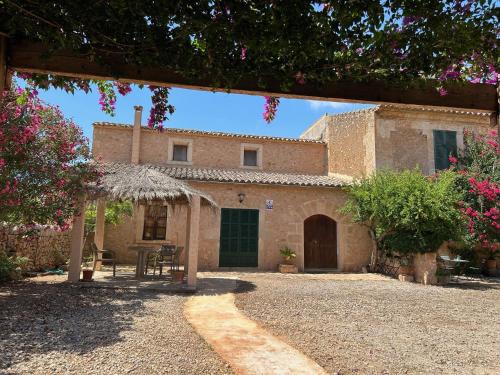 Casa de piedra antigua con mesa y patio en Finca Albenyeta, en Llucmajor
