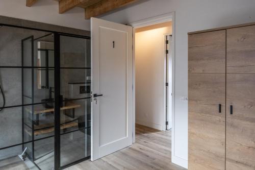 a room with a door leading into a room with wood at Newly Built Nature Villa, Wifi And Clean in Ledeacker