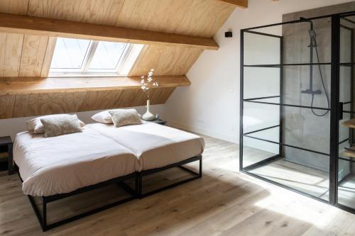a bedroom with a bed and a glass shower at Newly Built Nature Villa, Wifi And Clean in Ledeacker