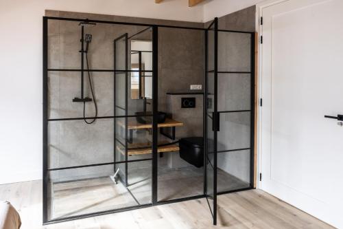 a shower with glass doors in a bathroom at Newly Built Nature Villa, Wifi And Clean in Ledeacker