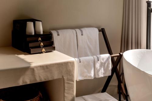 a bathroom with towels and a table and a sink at M ORIGINAL VILLA in Jinghong