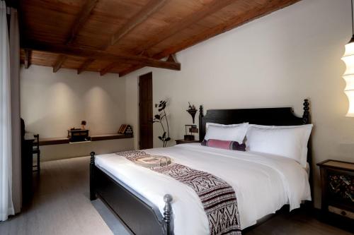 a bedroom with a large bed with white sheets at M ORIGINAL VILLA in Jinghong