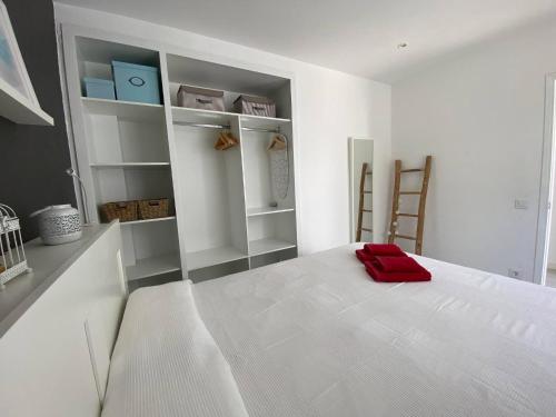een slaapkamer met een wit bed met een rode handdoek erop bij C-4 by SOM Menorca in Son Parc