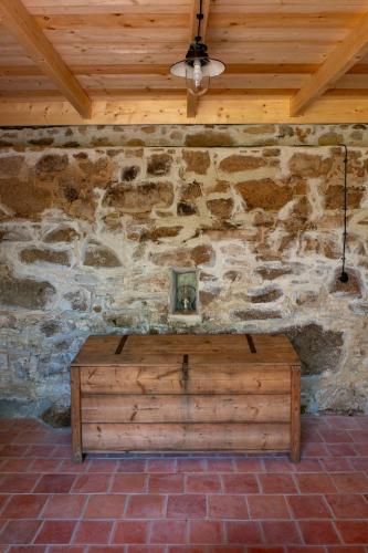 a room with a stone wall with a wooden ceiling at chalupa Pelechy in Kowářow