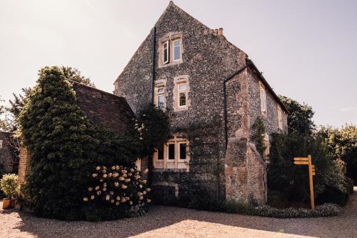 an old stone house with ivy on the side of it at Chapel House Estate in Kent