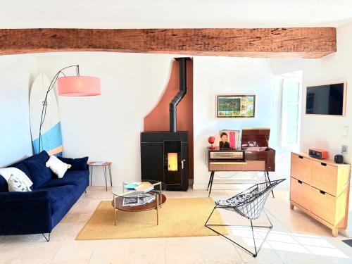 a living room with a blue couch and a fireplace at Maison nichée au coeur des vignes proche de Givry in Givry