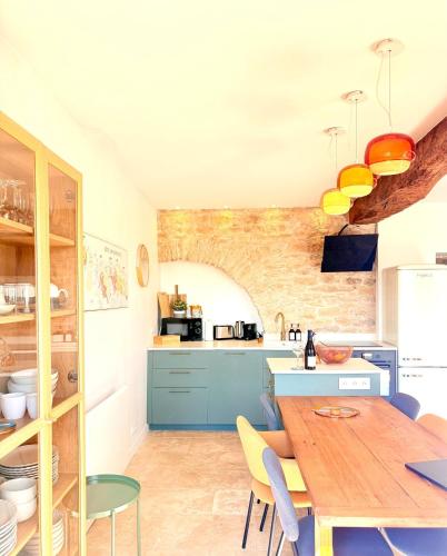 une cuisine avec une table en bois et des armoires bleues dans l'établissement Maison nichée au coeur des vignes proche de Givry, à Givry