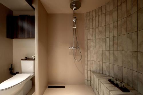 a bathroom with a shower with a toilet and a sink at M ORIGINAL VILLA in Jinghong