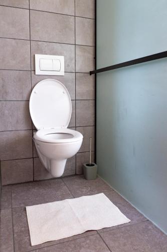 a bathroom with a toilet and a tile wall at chalupa Pelechy in Kowářow