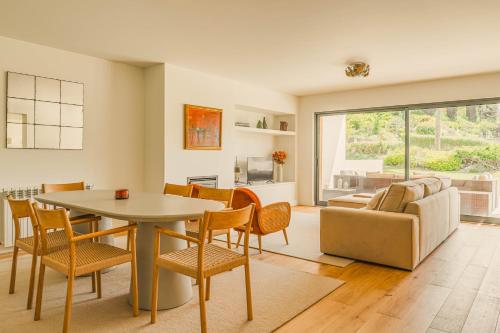 a living room with a table and chairs and a couch at Casa Cascais Riviera - Deluxe 3 Bedroom Apartment in Cascais