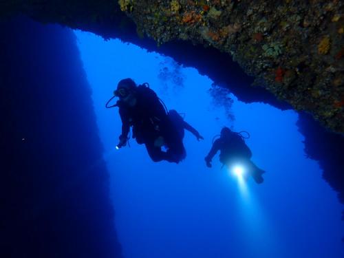two people diving into the ocean at night at Secret Garden Studios in Mytilini