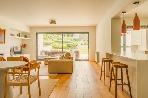 a kitchen and living room with a table and chairs at Casa Cascais Riviera - Deluxe 3 Bedroom Apartment in Cascais