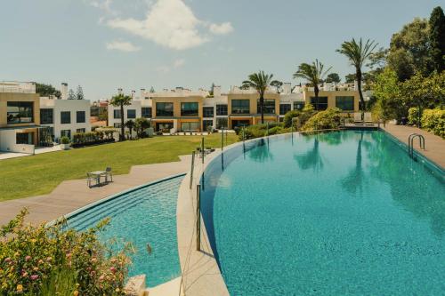 a large swimming pool in front of a building at Casa Cascais Riviera - Deluxe 3 Bedroom Apartment in Cascais