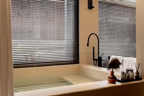 a bathroom with a tub and a large window at M ORIGINAL VILLA in Jinghong