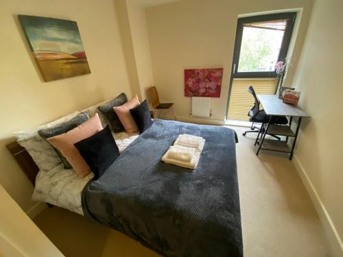 a large bed in a room with a couch at Canada Water 2Bedroom Apartment in London