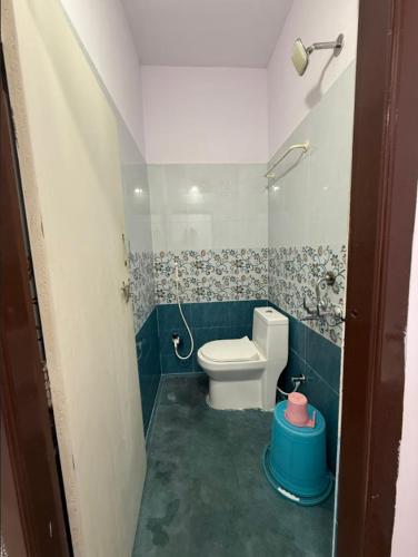 a bathroom with a white toilet and a blue wall at Hotel Udaan Villa in Hyderabad