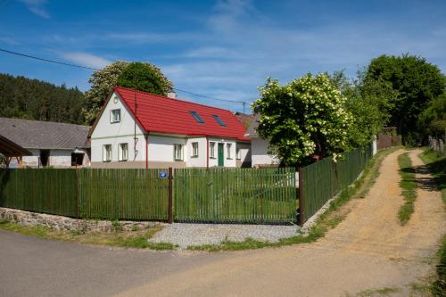 a house with a fence and a red roof at chalupa Pelechy in Kowářow